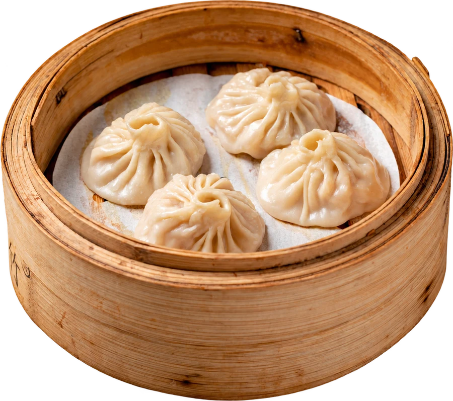 Four handmade Xiao Long Bao dumplings in a bamboo steamer